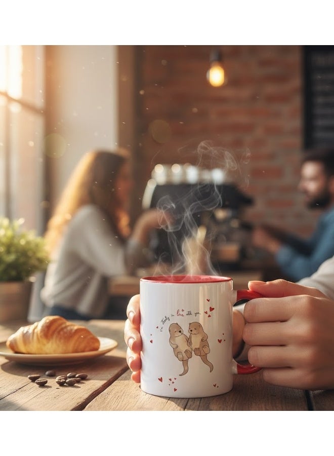 ميلز كوب سيراميك أحمر بلونين، عليه صورة زوجين لطيفين من ثعالب الماء يمسكان بأيدي بعضهما البعض، مكتوب عليه "مغرمان تمامًا". - Image 2